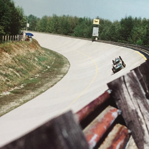 En formation serrée avec Innes Ireland sur l'ancien circuit de Monza avec son virage relevé typique En formation serrée avec Innes Ireland sur l'ancien circuit de Monza avec son virage relevé typique